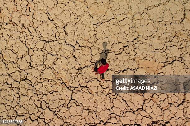 Youth walks on cracked and dried up soil at the Hawizeh marshes, which straddle Iraq's border with Iran, in the southeastern Maysan province on...