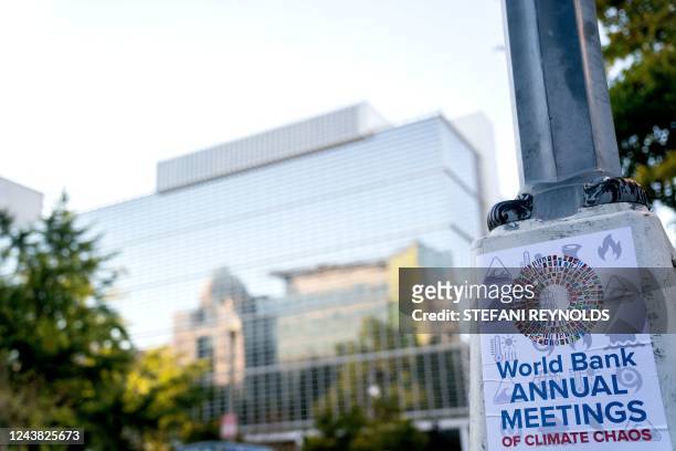 Sign posted in protest of the International Monetary Fund annual Fall Meetings is displayed outside of the World Bank headquarters in Washington, DC,...