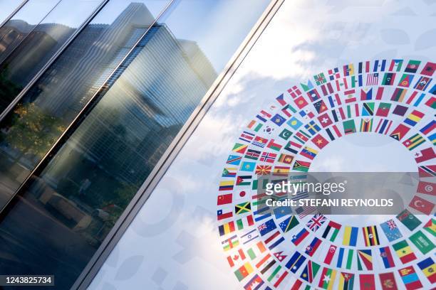The World Bank headquarters is reflected in a window of the International Monetary Fund headquarters in Washington, DC, on October 8, 2022. - The IMF...