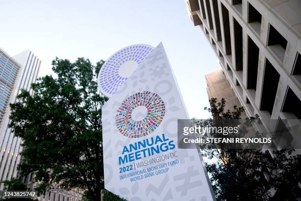 Sign for the International Monetary Fund annual Fall Meetings is displayed between the World Bank and IMF headquarters in Washington, DC, on October...