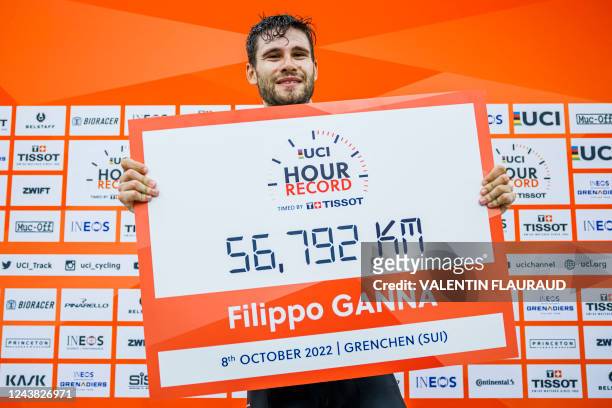 Ineos Grenadiers' Italian rider Filippo Ganna poses with a placard after breaking the hour record with a distance of 56.792km in the Velodrome...