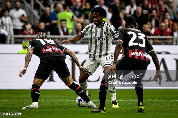Theo Hernandez of AC Milan and Fikayo Tomori of AC Milan tackle Juan Cuadrado of Juventus during the Italian Serie A football match AC Milan vs...