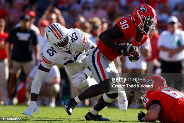 Daijun Edwards of the Georgia Bulldogs breaks away from Colby Wooden of the Auburn Tigers to score in the first half at Sanford Stadium on October 8,...