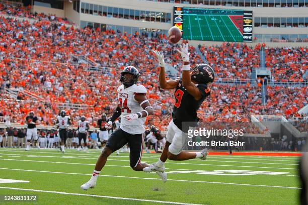Wide receiver Bryson Green of the Oklahoma State Cowboys grabs a 28-yard catch against defensive back Malik Dunlap of the Texas Tech Red Raiders in...