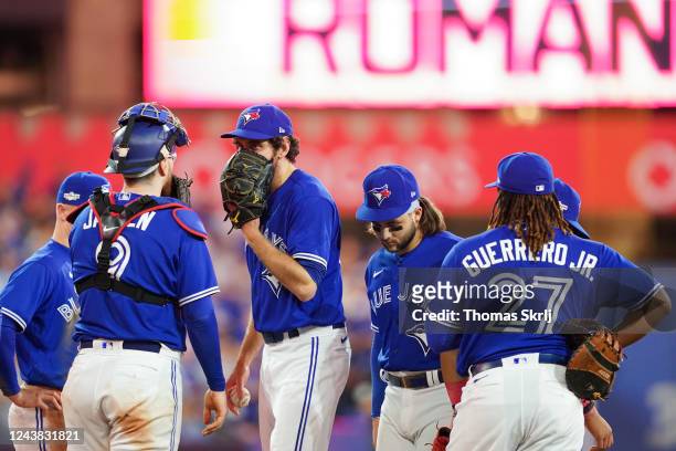 Players from the Toronto Blue Jays meet on the mound in the eighth inning during the Wild Card Series game between the Seattle Mariners and the...
