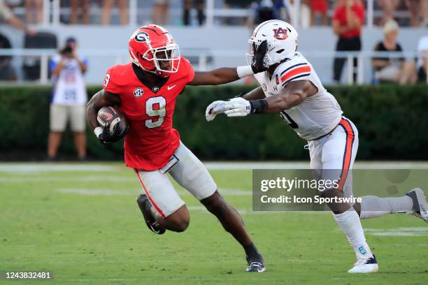 Auburn Tigers linebacker Owen Pappoe is stiff armed by Georgia Bulldogs wide receiver Jackson Meeks during the Saturday afternoon college football...