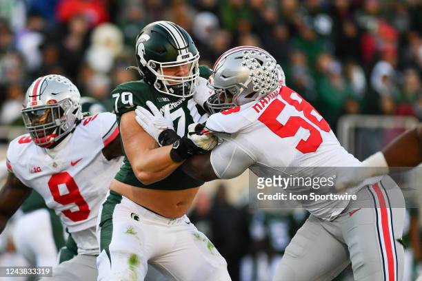 Michigan State Spartans offensive tackle Jarrett Horst battles with Ohio State defensive tackle Ty Hamilton during a college football game between...