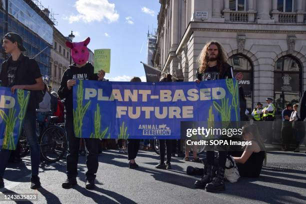 Animal Rebellion activists hold a "Plant based future" banner in Pall Mall during the protest. The animal rights group marched in Central London...