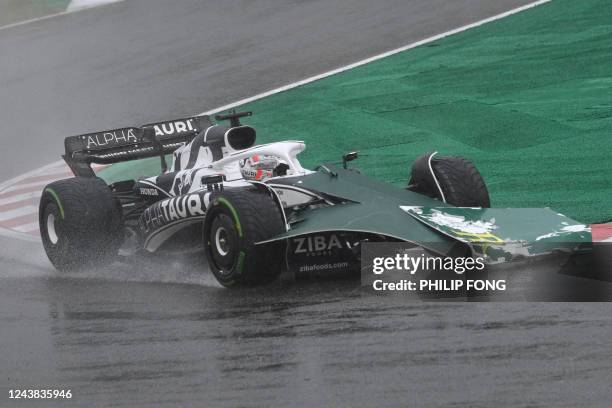 Some signage blows onto the front of the car of AlphaTauri's French driver Pierre Gasly during a rainstorm at the Formula One Japanese Grand Prix at...