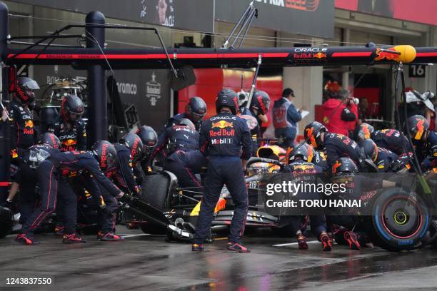 Mechanics work on the car of Red Bull Racing's Dutch driver Max Verstappen in the pit during the Formula One Japanese Grand Prix at Suzuka, Mie...