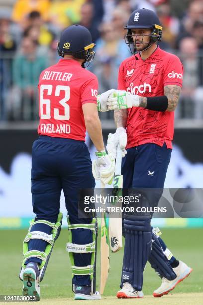 England's of Alex Hales and Jos Buttler bump gloves during the first cricket match of the Twenty20 series between Australia and England in Perth on...