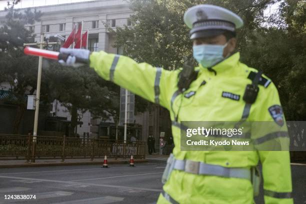 Police officer patrols on Oct. 9 near the venue of the seventh plenary session of the Communist Party of China's 19th Central Committee starting the...