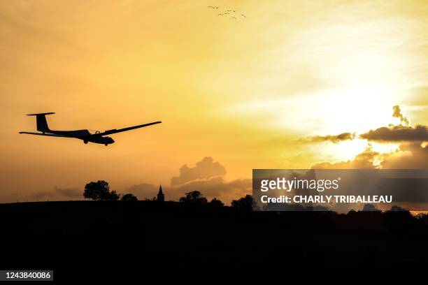 Glider lands during the sunset near the town of Bourg-Saint-Bernard, southwestern France on October 8, 2022.