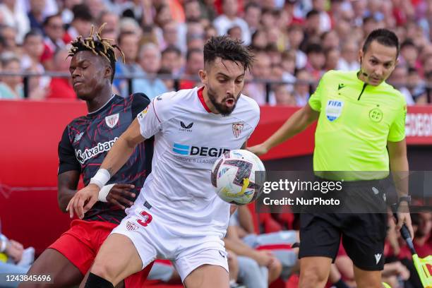 Alex Telles of Sevilla FC competes for the ball with Nico Williams of Athletic Club during the La Liga Santader match between Sevilla CF and Athletic...