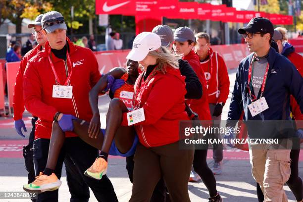 Kenya's Vivian Kiplagat is carried away from the finish line after placing third in the women's division of the 2022 Bank of America Chicago Marathon...