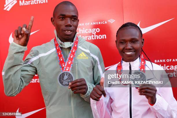 Kenya's Benson Kipruto, who placed first in the men's division, and Kenya's Ruth Chepngetich, who placed first in the women's division, hold up their...