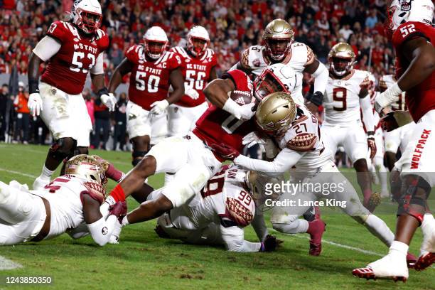 Demie Sumo-Karngbaye of the North Carolina State Wolfpack is tackled by Akeem Dent of the Florida State Seminoles at Carter-Finley Stadium on October...