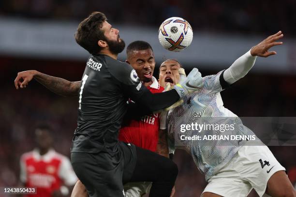 Liverpool's Brazilian goalkeeper Alisson Becker and Liverpool's Dutch defender Virgil van Dijk clash with Arsenal's Brazilian striker Gabriel Jesus...