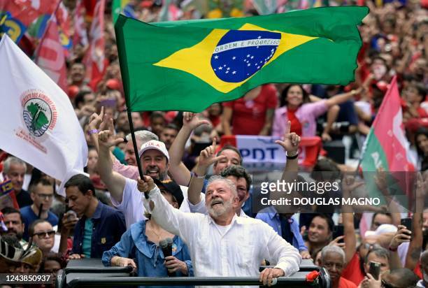Brazil's former President and presidential candidate for the leftist Workers Party Luiz Inacio Lula da Silva waves a national flag during a campaign...