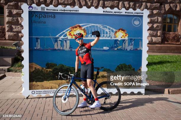 Man takes a selfie with a stamp model depicting the burning Crimean bridge in the background, in central Kyiv. On October 8, an explosion occurred on...