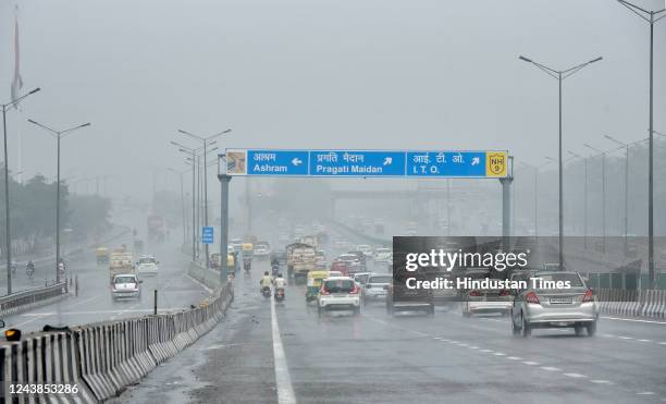 Commuters out in the rain on NH-34, on October 9, 2022 in New Delhi, India. Heavy rains are lashing parts of Delhi leading to traffic snarls in...