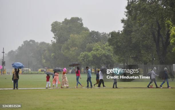 Tourists out in the rain at India Gate, on October 9, 2022 in New Delhi, India. Heavy rains are lashing parts of Delhi leading to traffic snarls in...