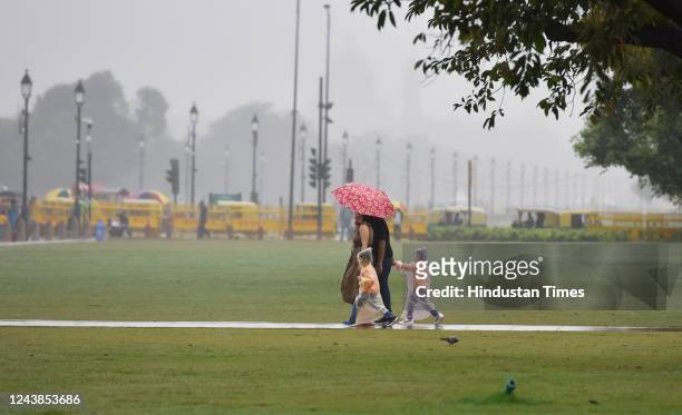 Tourists out in the rain at India Gate, on October 9, 2022 in New Delhi, India. Heavy rains are lashing parts of Delhi leading to traffic snarls in...
