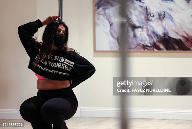 Saudi yoga instructor Nada, exercises by pole dancing at a local gymnasium in the capital Riyadh, on October 1, 2022. - When Nada took up pole...