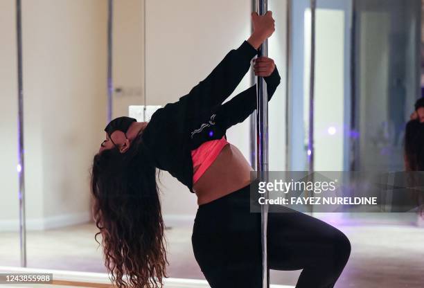 Saudi yoga instructor Nada, exercises by pole dancing at a local gymnasium in the capital Riyadh, on October 1, 2022. - When Nada took up pole...