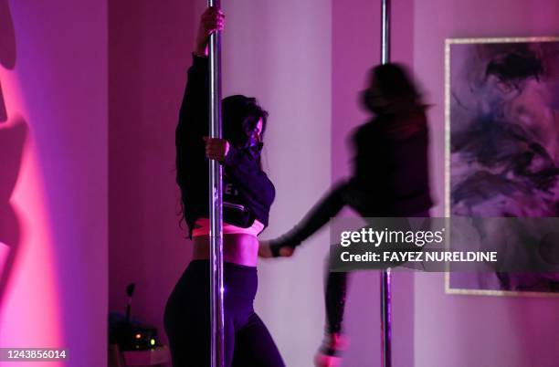 Saudi yoga instructor Nada , and another woman exercise by pole dancing at a local gymnasium in the capital Riyadh, on October 1, 2022. - When Nada...