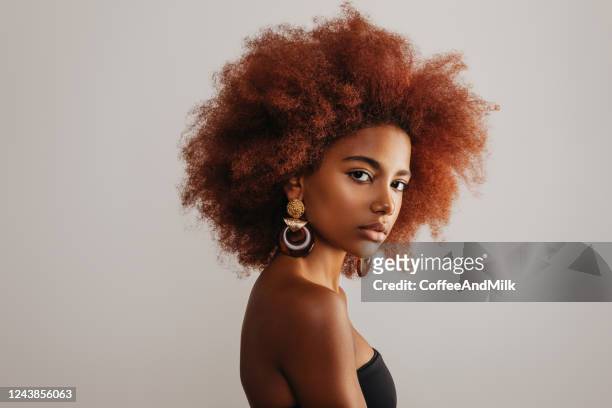schöne afro-mädchen mit ohrringen - afro frisur stock-fotos und bilder