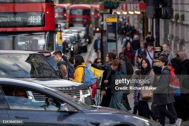 Pedestrians cross the road in front of heavy traffic at the top of Whitehall in the capital, on 6th October 2022, in London, England.