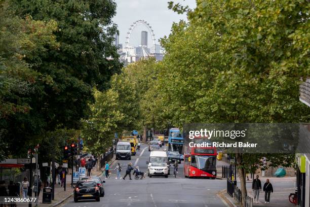 The London Eye is seen above local plane trees and south London traffic on Denmark Hill in Camberwell, on 6th October 2022, in London, England.