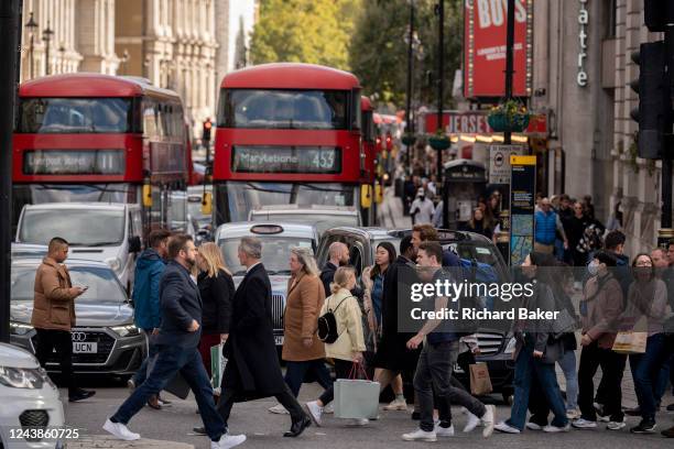 Pedestrians cross the road in front of heavy traffic at the top of Whitehall in the capital, on 6th October 2022, in London, England.