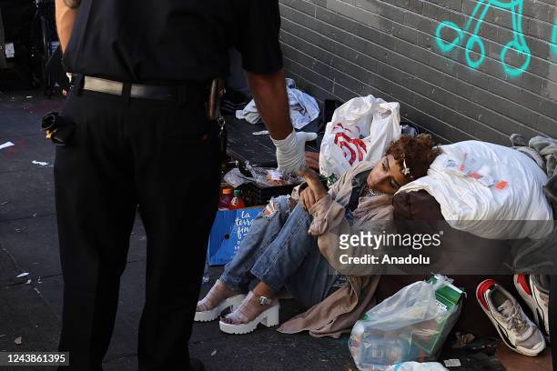 Paramedic helps a homeless woman who is in drug at Tenderloin district of San Francisco in California, United States on October 9, 2022.