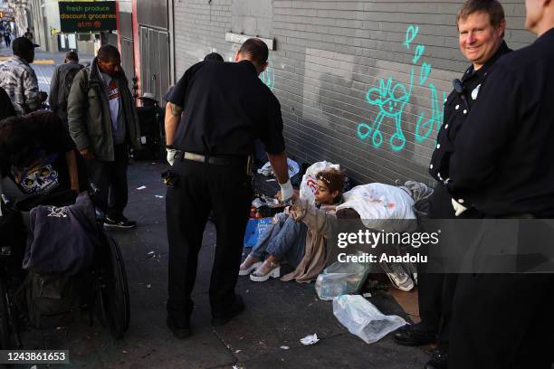 Paramedic helps a homeless woman who is in drug at Tenderloin district of San Francisco in California, United States on October 9, 2022.