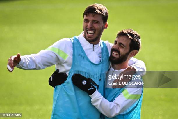 Manchester City's Portuguese defender Ruben Dias and Manchester City's Portuguese midfielder Bernardo Silva laugh as they attend a team's training...