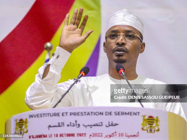 Mahamat Idriss Deby raises his hand as he is sworn in as Chad's transitional president, in NDjamena on October 10, 2022.