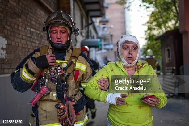 Fireman helps injured civilians after several explosions rocked the Shevchenkivskyi district of the Ukrainian capital, Kyiv on October 10, 2022.