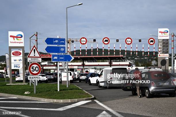 Vehicles wait in line to refuel at a TotalEnergies petrol station on the outskirts of Lyon, on October 10, 2022. - Despite repeated calls from the...