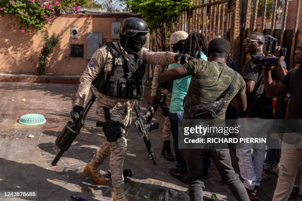 Police officer prevents protesters from entering a hotel that was just looted during a protest against Haitian Prime Minister Ariel Henry calling for...