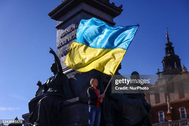 Boy holds Ukrainian flag during a demonstration of solidarity with Ukraine at the Main Square, after latest Russian missiles targeted civilian...