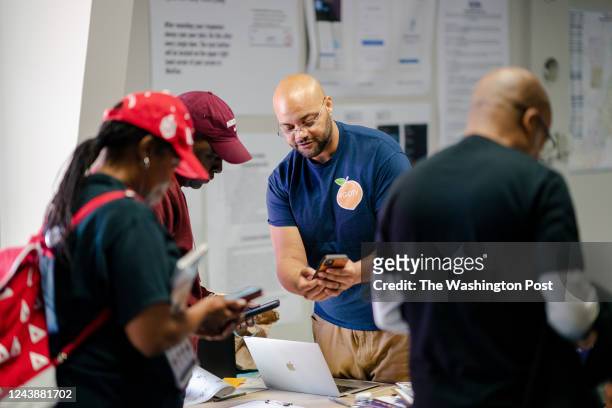 Corey Smith, regional field director for Fulton and Dekalb counties for the Stacey Abrams campaign, helps canvassers before they head out to recruit...