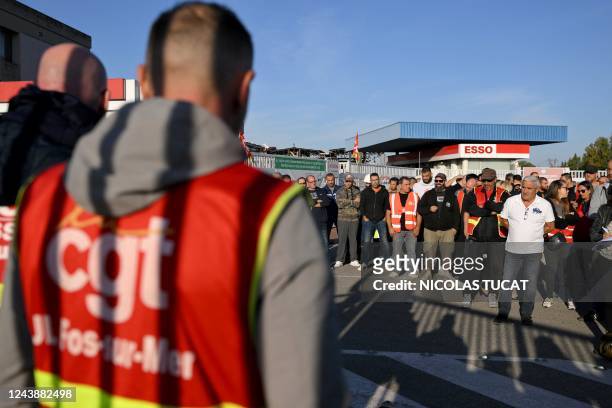 Striking workers and unionists of the CGT gather outside Esso's oil refinery in Fos-sur-Mer, southern France, on October 11, 2022. - Around a third...