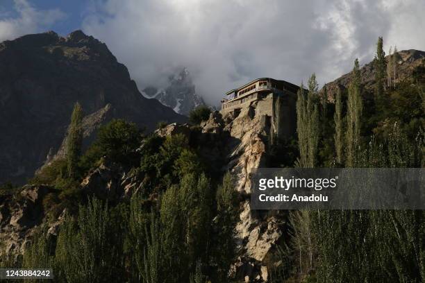 View of a building on top of a rocky ledge in Hunza Valley in Gilgit-Baltistan region of Pakistan on October 11, 2022. Surrounded by high mountains...