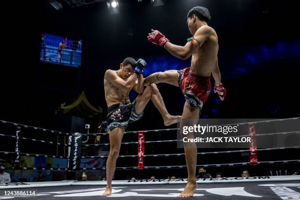 In this photo taken on September 24 Muay Thai boxer Theppharat S. Noppharat from Thailand strikes his Mexican opponent Juan Gonzales during their...