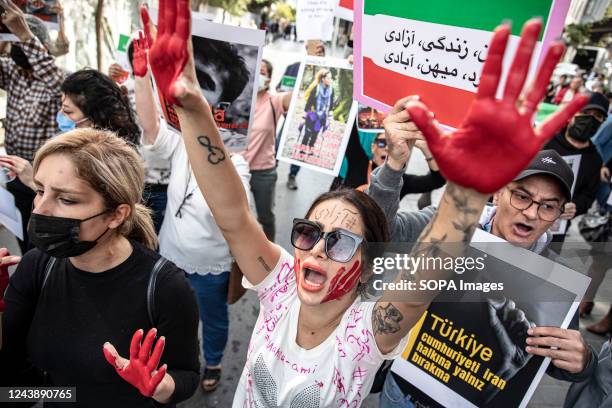 Protesters chant slogans with red painted hands and faces during the demonstration. The protest was held in front of the Iranian Consulate in...