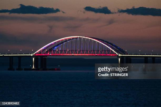 View taken on October 11, 2022 shows the Kerch Bridge that links Crimea to Russia at dusk, near Kerch, which was hit by a blast on October 8, 2022. -...