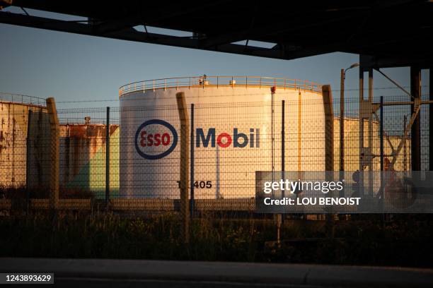 Car drives past storage tanks with the "Esso-ExxonMobil" logo of the Esso-ExxonMobil refinery site, in Port-Jerome-sur-Seine, near Le Havre,...