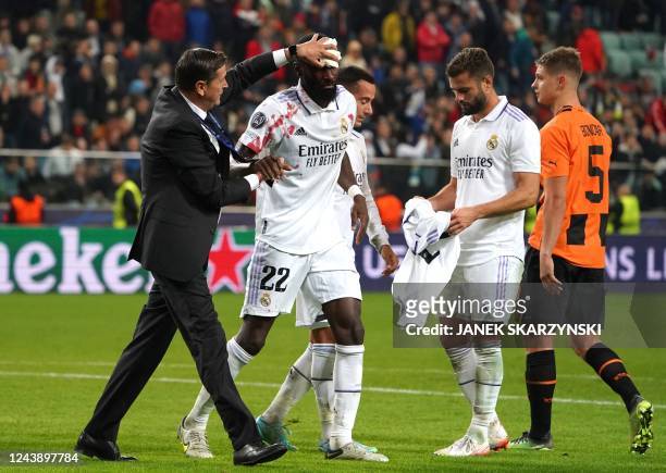 Real Madrid's German defender Antonio Rudiger is attended for an injury after scoring the 1-1 goal during the UEFA Champions League group F football...